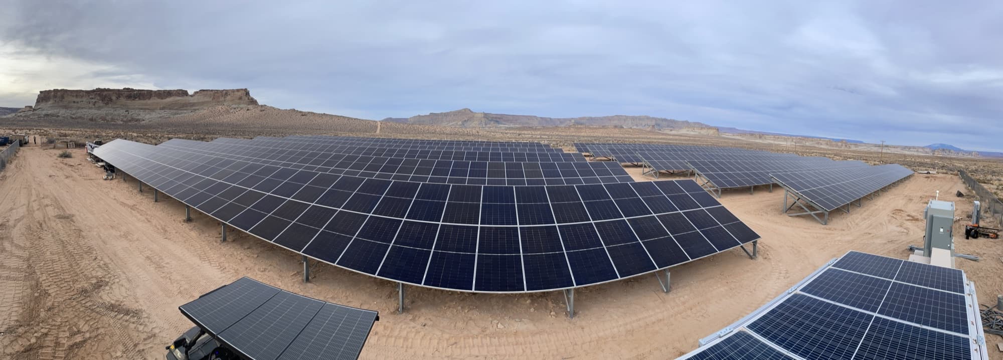 Panoramic view of a large-scale ground-mount solar array in the Southern Utah desert
