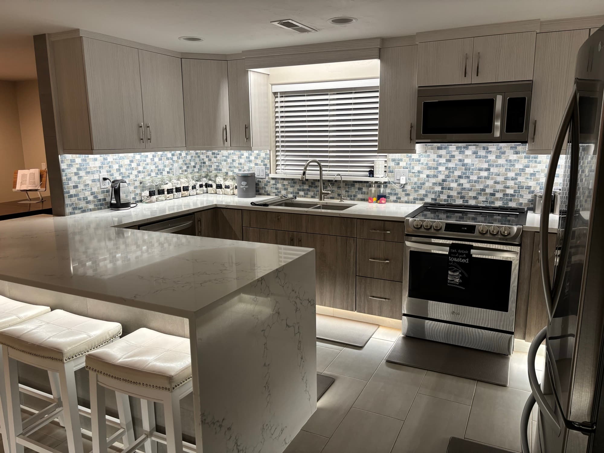 Warm under-cabinet lighting in a new construction kitchen, showing precision electrical work