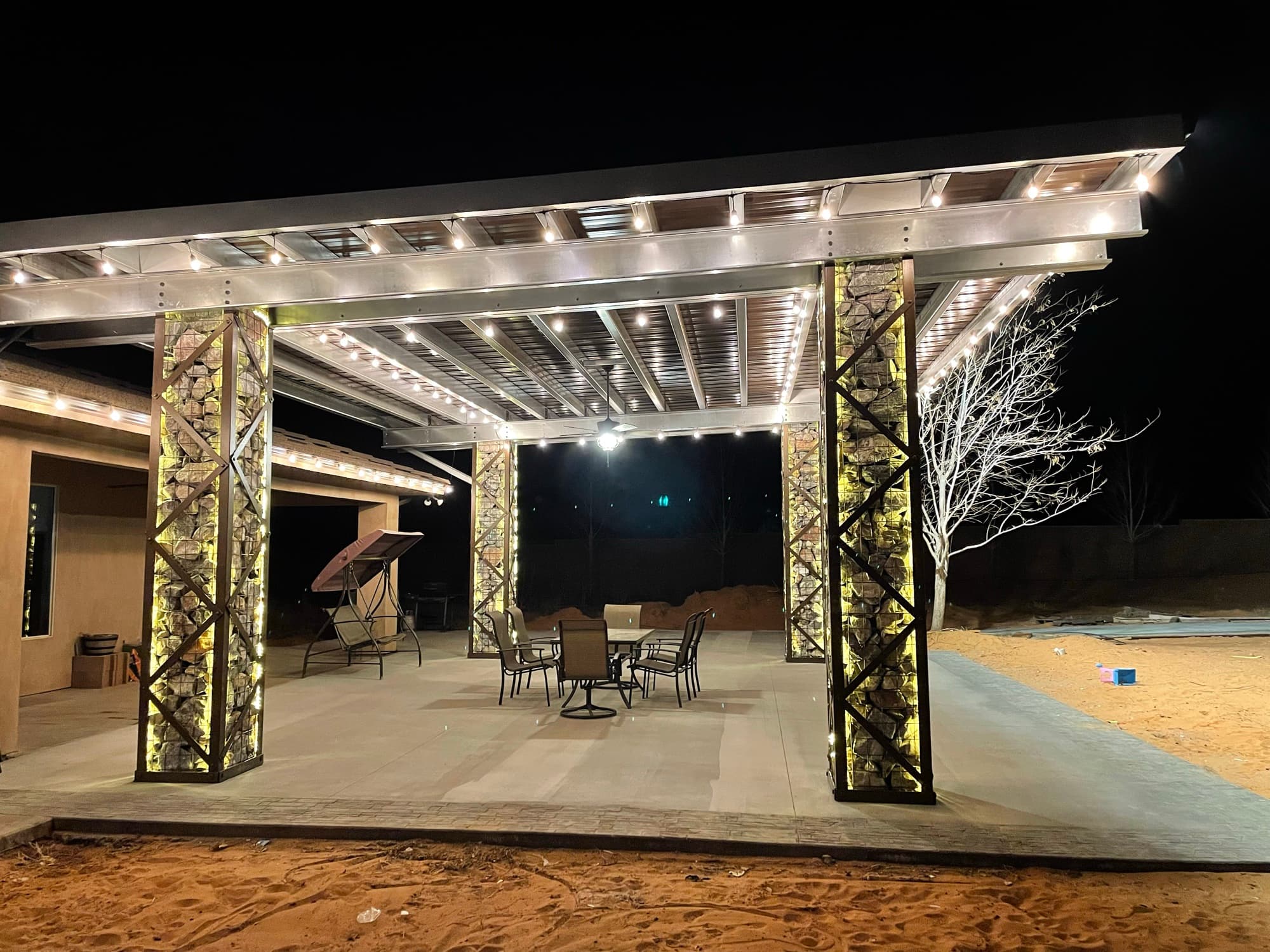 Solar pavilion at night with glowing LED lighting on rafters and columns